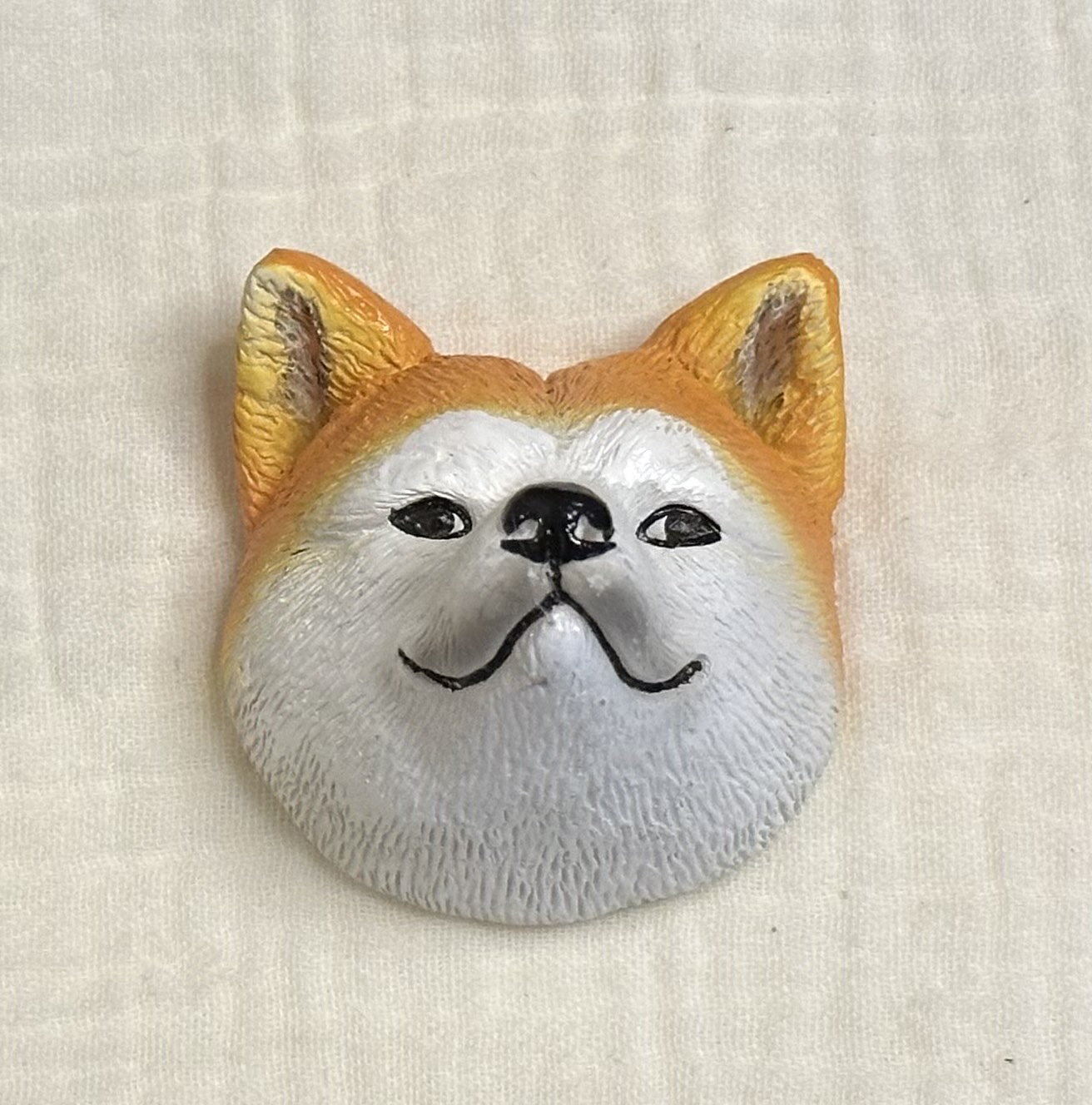 ドン・キホーテで購入した、白と茶色の秋田犬のご当地立体マグネット